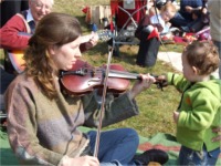 Kathleen O�Hara Farren plays a tune on the fiddle with the help of little Odhran Lafferty from Ballybrack.
